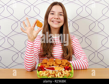 Happy teenage Mädchen mit Chicken Nuggets und Pommes frites Fast Food Stockfoto