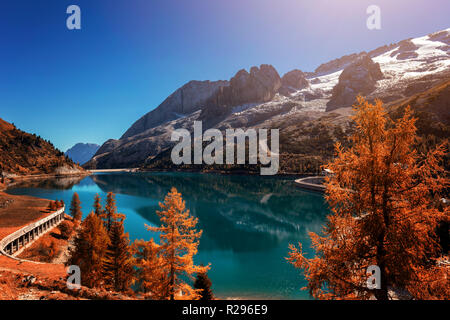 Schönen Herbst Farben bei Fedaia See mit Marmolada Gipfel durch Eis, Dolomiten, Italien Stockfoto