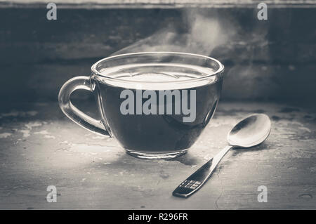 Heiße Tasse schwarzen Tee mit Dampf auf einem alten Fensterbank Stockfoto