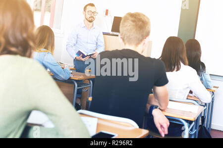 Männliche Lehrer gibt interessante Vortrag für Schüler im Klassenzimmer Stockfoto