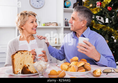 Positive reifes Paar mit Frühstück in festliche Weihnachten Tabelle Stockfoto