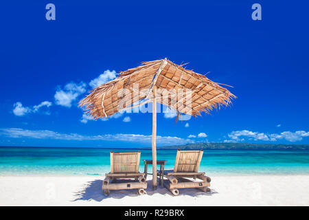Urlaub ferien Hintergrund - zwei Liegestühle unter Zelt am Strand Stockfoto