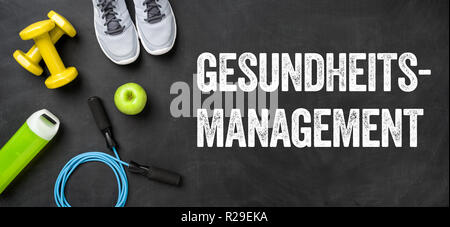 Fitnessgeräte auf dunklem Hintergrund - Gesunderhaltung (deutsches Wort für Gesundheit Management) Stockfoto
