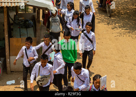 Don Khone, Laos - 24. April 2018: Die UNIFORMIERTEN Hochschule Kinder wandern durch ein Dorf im südlichen Laos Stockfoto