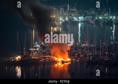 Während der Nacht, Feuerwehrmänner versuchen, zwei luxuriöse Yachten, die Feuer an der Marina Liegeplatz zu fangen sind. Stockfoto