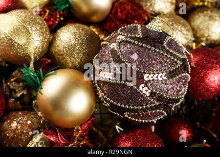 Eine Menge runde Spielzeug am Weihnachtsbaum. auf einem Hintergrund von Gold und Rot Spielzeug von Hand bemalten Kugel Stockfoto