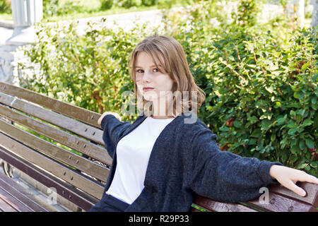 Schöne Mädchen, 14 Jahre alt, sind auf der Bank sitzen Stockfoto