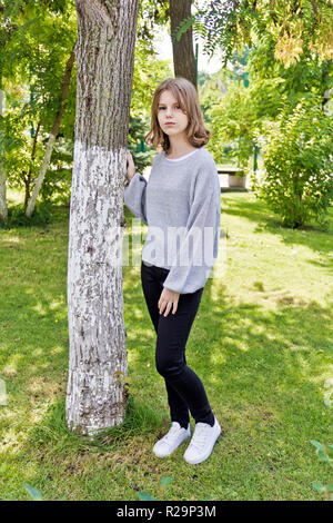 Schöne Mädchen, 14 Jahre alt auf dem Baum lean Stockfoto