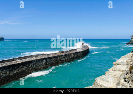 Surfen brechen über den Hafen Wand aus Portreath Cornwall GROSSBRITANNIEN Stockfoto