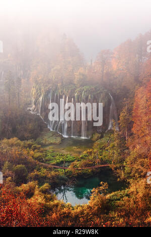 Luftaufnahme auf erstaunlich nebligen Wasserfall im Nationalpark Plitvicer Seen. Orange Herbst Wald für den Hintergrund. Nationalpark Plitvice, Kroatien. Landschaftsfotografie Stockfoto