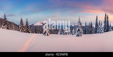 Fantastische orange Winterlandschaft in Snowy Mountains glühende durch Sonnenlicht. Dramatische winterliche Szene mit verschneiten Bäumen. Weihnachten Konzept. Stockfoto