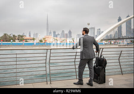 Arabische Geschäftsmann mit seinem Koffer in einer Stadt von Dubai Stockfoto