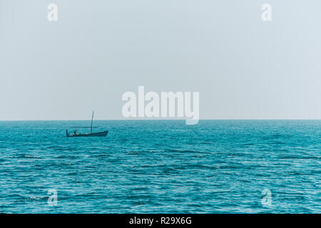 Kleines Boot Angeln in endlosen Ozean Wasser. Stockfoto