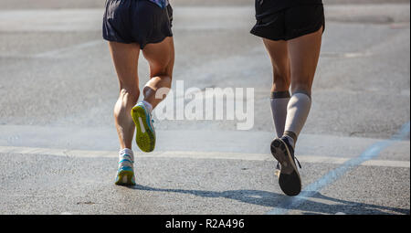 Marathon Rennen, zwei Läufer auf innerstädtischen Straßen, Detail auf Beinen, Rückansicht Stockfoto