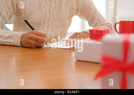 Mann mit Creme Pullover schreiben Weihnachten schreiben Grußkarte Urlaub wünsche. Weihnachten feiern. Stockfoto