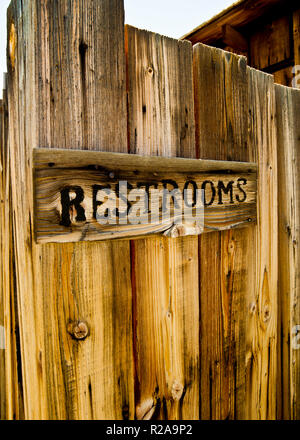 Toilettenschild aus Holz Schriftzug ausgebrannt, montiert auf alten Hölzern in Geisterstadt Bodie, Kalifornien, USA. Stockfoto