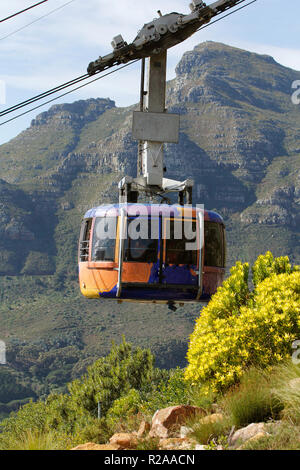 Eine der Table Mountain Bergbahnen auf dem Weg nach oben auf den Tafelberg, mit Devils Peak hinter sich. Stockfoto