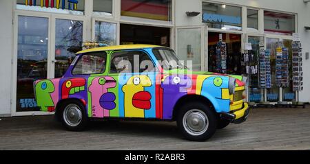 Eine bunte alte Trabant vor einem Souvenirshop in den Arkaden Shopping Center in der Nähe Potsdamer Platz, Berlin, Deutschland geparkt. Stockfoto