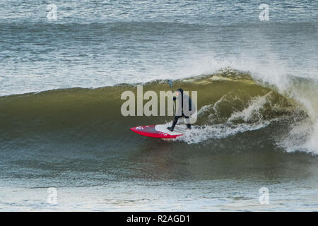 Aberystwyth Wales, UK. 18 Nov, 2018. UK Wetter: Hardy Surfer früh auf die beeindruckenden Wellen in der Morgensonne in Aberystwyth auf der Cardigan Bay Küste von West Wales zu fangen. Foto credite Kredit: Keith Morris/Alamy leben Nachrichten Stockfoto