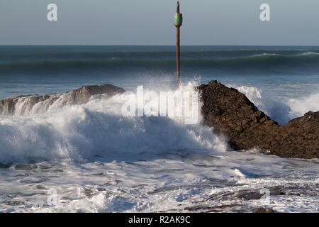 Cornwall, UK. Nov 2018 18. Surfer Fahrt die riesigen Wellen in Bude, Cornwall, als Leute, die die meisten der Sonne und am Strand entlang machen beim Gehen ihre Hunde. Credit: Keith Larby/Alamy leben Nachrichten Stockfoto