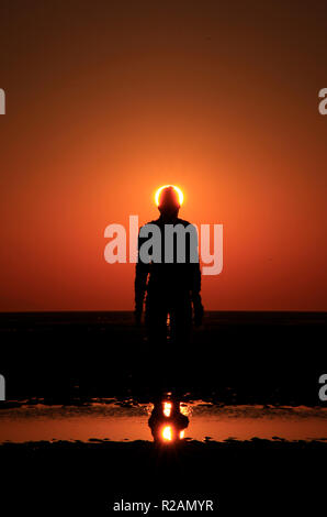 Crosby, UK. 18. November 2018. Klarer Himmel am Ende eines kalten sonnigen Tag, als die Sonne über Anthony's Gormley" an einen anderen Ort "Kunst installation, Bügeleisen vermummte Gestalten auf Crosby Strand feste Sätze. Das Wetter ist diese Woche trüber zu drehen. Premos/Alamy leben Nachrichten Stockfoto