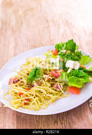 Appetitliche und frische Spaghetti Carbonara Nudeln mit Mozzarella Salat auf der Seite Stockfoto