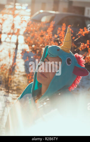 Cute woman in kigurumi Einhorn Kostüm auf der Straße Stockfoto