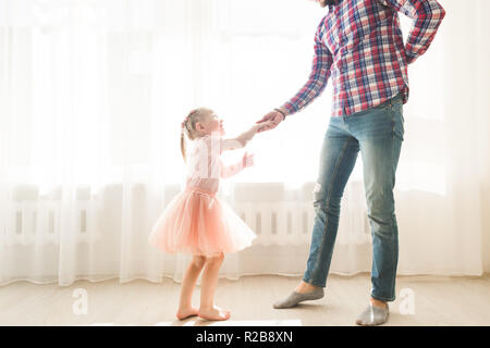 Vater lehrt seine kleine süße Tochter zu tanzen. Stockfoto