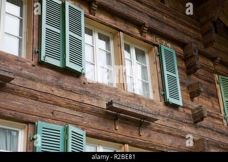 In der Nähe von Fenstern und Fensterläden eines traditionellen Holzchalet auf Alte Staatsstraße, Wilderswil: Berner Oberland, Schweiz Stockfoto