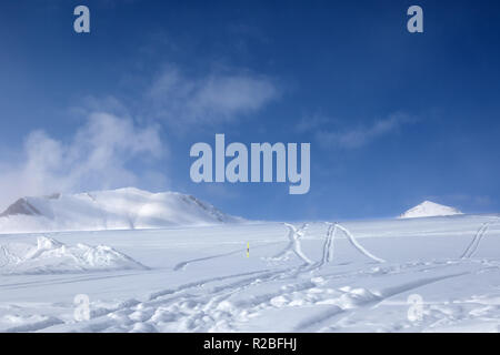 Off-piste Skipiste mit neuen - Schnee und Spuren von Skiern, Snowboards gefallen nach Schneefall. Kaukasus Berge im Nebel bei Sun winter Abend, Georgien, re Stockfoto