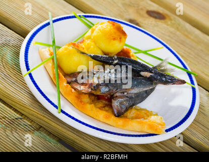 Teller lecker gebratene Sprotten mit gebratenen Kroketten und Kuchen auf Platte Stockfoto