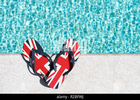 Britischer Flagge oder Union Jack gedruckt flip-flops neben dem Pool Stockfoto