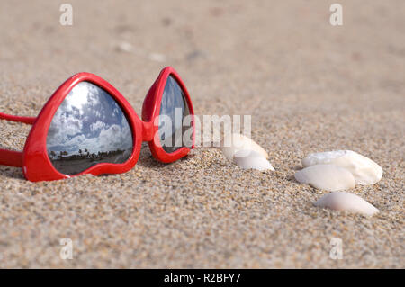 Nahaufnahme der modischen Herzförmige rote Sonnenbrille an einem Sandstrand Stockfoto