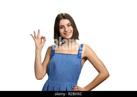 Glückliche junge Frau, ok Zeichen mit den Fingern. Portrait von Happy stilvolle Mädchen geben okay, auf weißem Hintergrund. Stockfoto