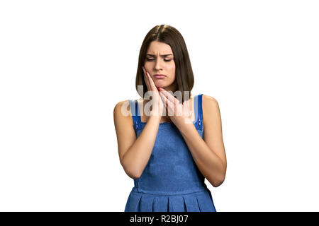 Junge Frau in starke Zähne schmerzen. Schöne umgekippt Mädchen leiden von Zahn ache Über weißen Hintergrund. Zahn Schmerz und Zahnheilkunde. Stockfoto