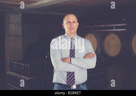 Sicher froh, dass positive erfolgreiche Mann Winzer im eigenen Weingut vault Posing Stockfoto