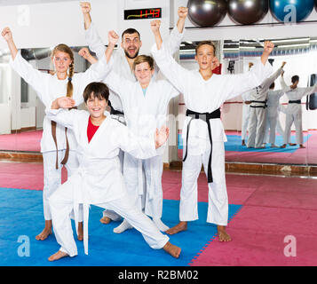 Portrait von glückliche Kinder und männliche Trainer in kimonos vor Karate Training Stockfoto