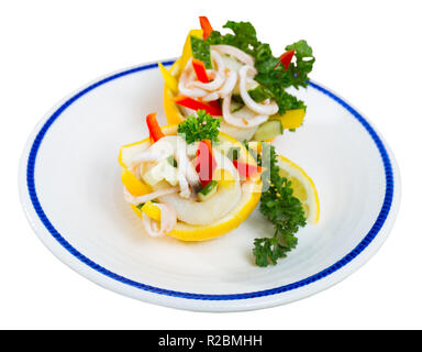 Lecker Salat mit Calamari und frisches Gemüse, in Zitronen mit Olivenöl und Joghurt Sauce serviert. Auf weissem Hintergrund Stockfoto