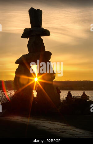 Vancouver Inukshuk Sonnenuntergang. Menschen für einen Spaziergang bei Sonnenuntergang an der English Bay, Vancouver. Stockfoto