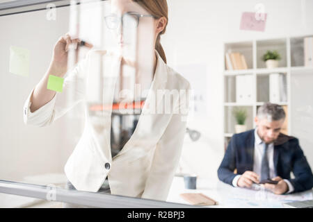 Lady konzentriert sich Notizen während der Arbeit an marketing Projek Stockfoto