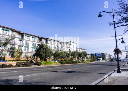 Licht Verkehr auf einer Straße in Santa Clara an einem sonnigen Tag, mehrfamilien Gehäuse Entwicklung auf der Seite der Straße; San Francisco Bay Area, Kalifornien Stockfoto