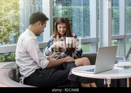 Closeup gerne asiatische Schöne junge geschäftsfrau im Gespräch mit Geschäftsmann mit formalen Anzüge in modernen Büro, Geschäft Leute Konzept Stockfoto