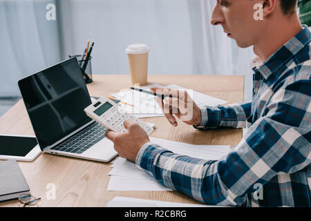 Teilweise mit Blick auf die Unternehmer mit dem Rechner am Arbeitsplatz mit Dokumenten und Laptop arbeiten Stockfoto