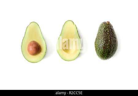 Frische Avocado. Ganze avocado Obst und zwei Hälften in einer Reihe auf weißem Hintergrund, Ansicht von oben Stockfoto