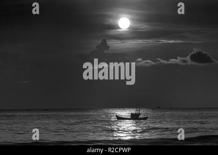 Schöne Strandszene am Morgen, wenn die Sonne neben dem Fischerboot der Fischer aufgeht, als neuen interessanten Tag zu begrüßen. Stockfoto