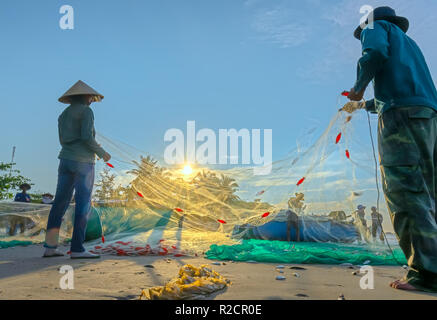 Fischer machen nach dem Fangen im Küstenfischereidorf Fischernetz. Das ist harte Arbeit, aber viele Familien in Phan Thiet, Stockfoto