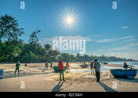 Fischer machen nach dem Fangen im Küstenfischereidorf Fischernetz. Das ist harte Arbeit, aber viele Familien in Phan Thiet, Stockfoto