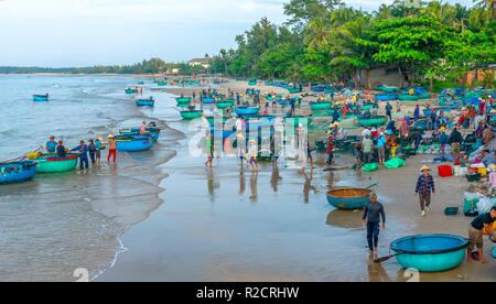 Fischmarkt Sitzung Seeszene Menschen versammelten sich im Korb Fischverkauf, anstrengende Ruderfischerei Fischer Fisch an Land gebracht Fischerdorf in Phan Thiet Stockfoto