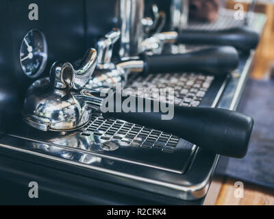 Portafilter mit der Oberseite nach unten auf eine Kaffeemaschine auf hölzernen Tisch im Café. Stockfoto
