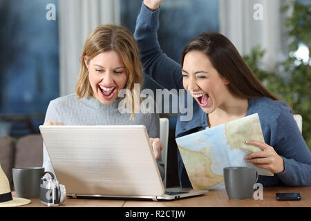 Zwei begeistert Touristen finden online bieten in einem Laptop im Hotel Zimmer oder Apartment Stockfoto